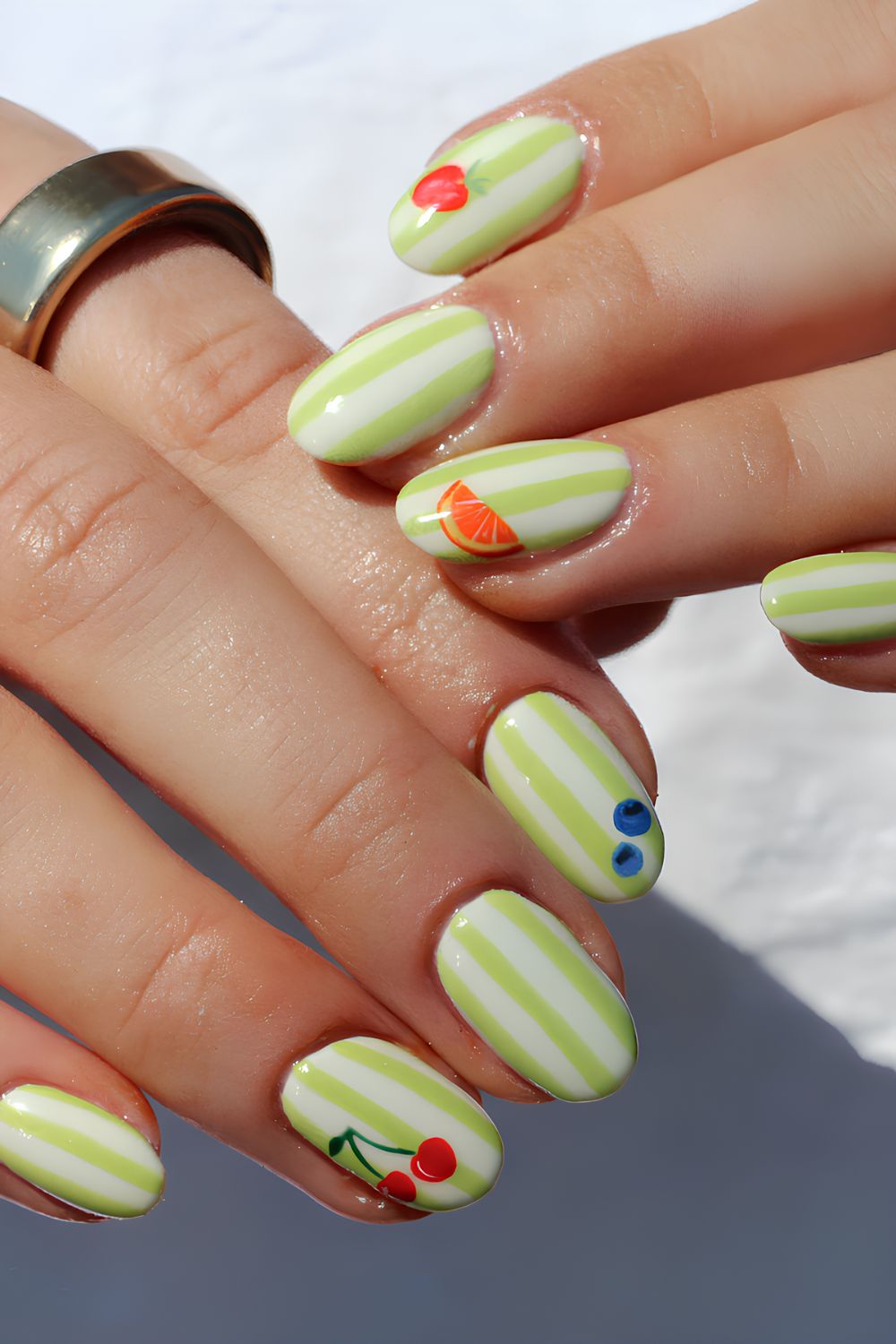 Lime green and white stripe nails with fruit decals