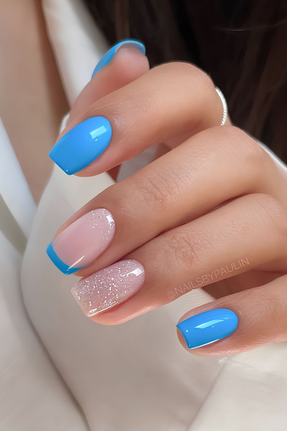 Mid blue nails with glitter and accent French tips