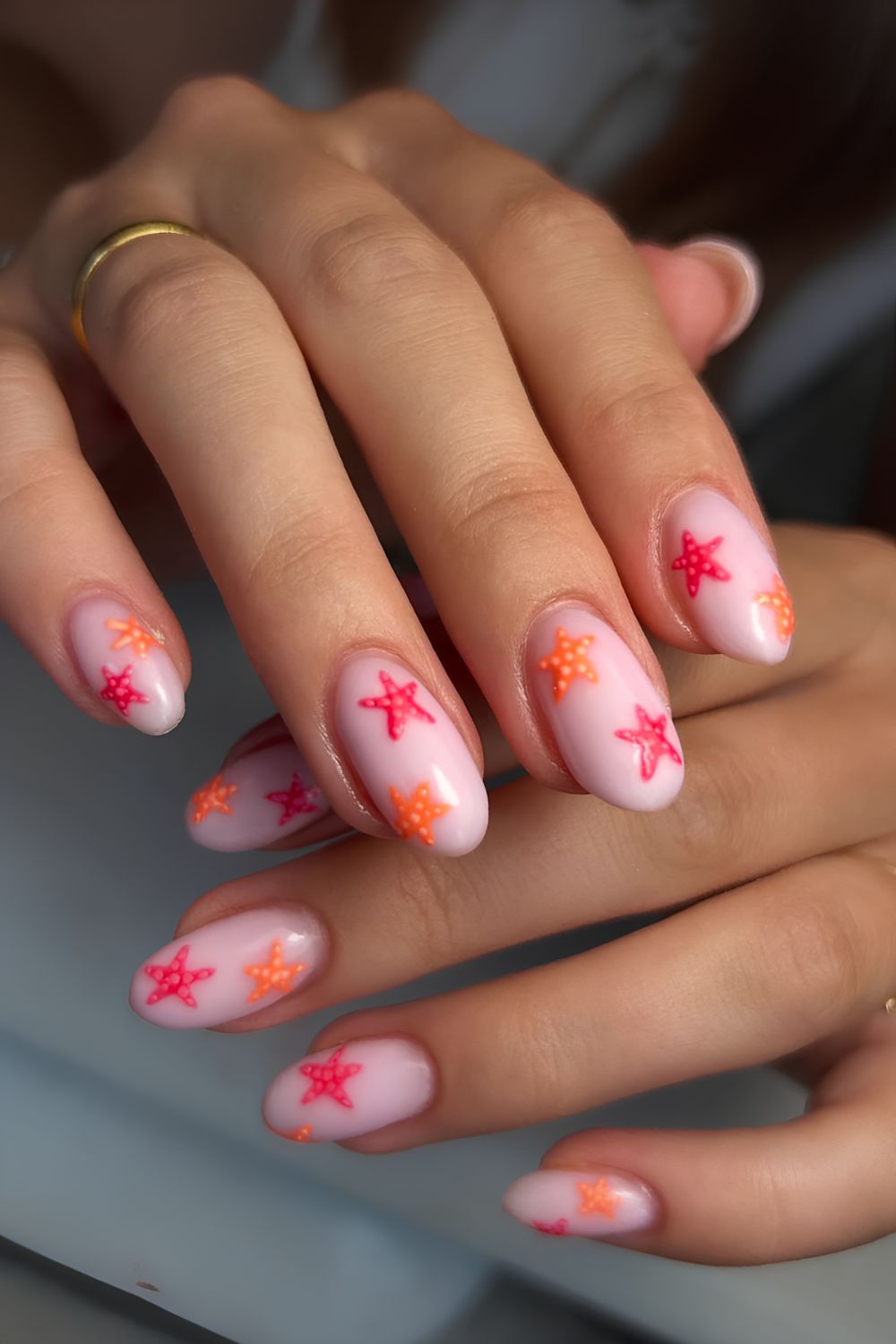Milky pink with orange and pink starfish nail design