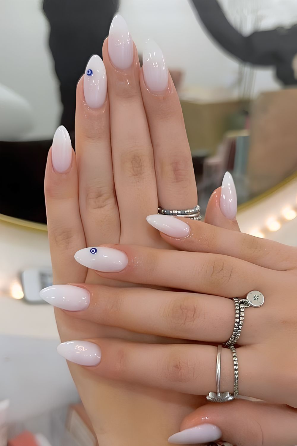 Milky white nails with evil eye deacals on accent nails
