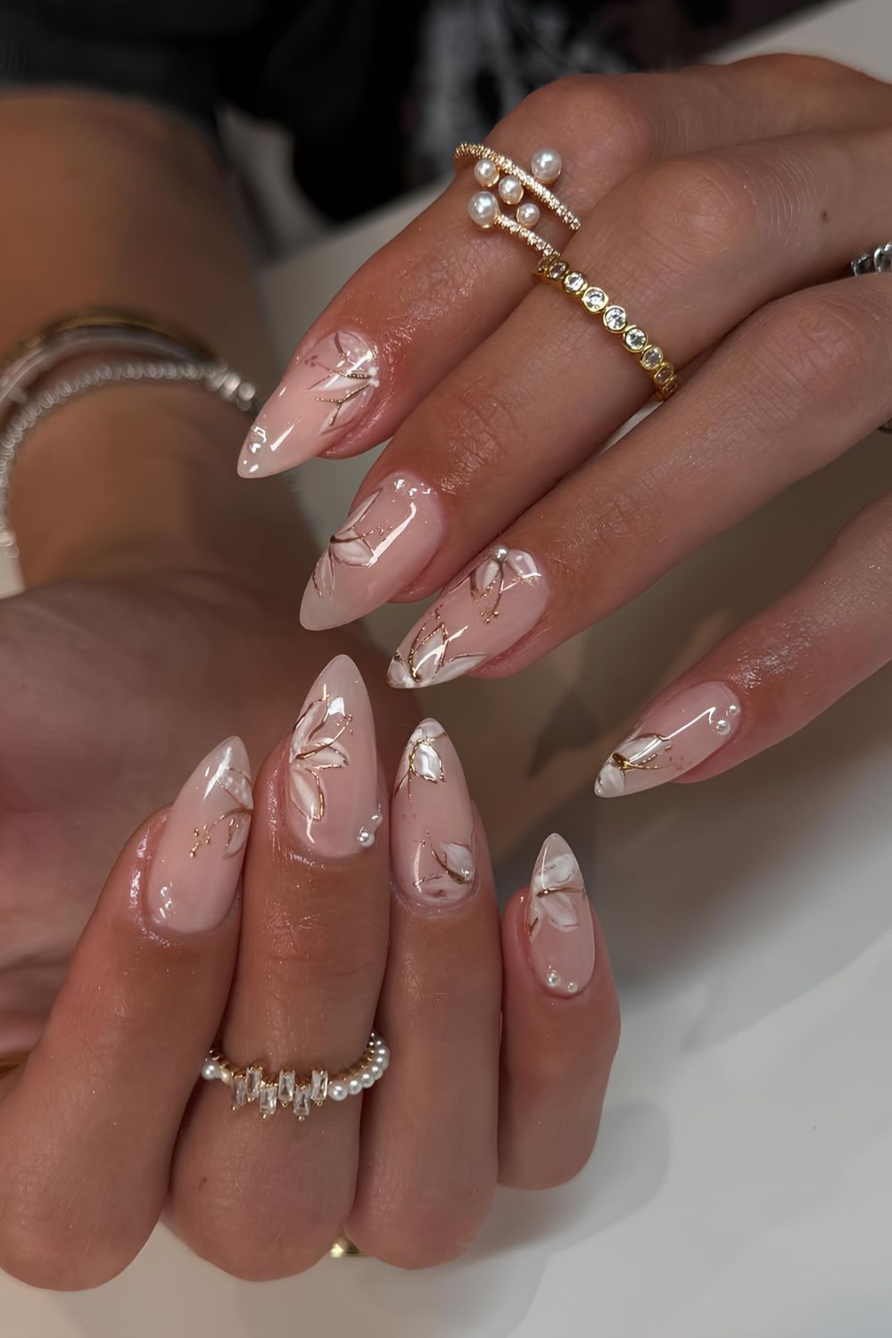 Neutral glossy mani with white florals and gold chrome outlines