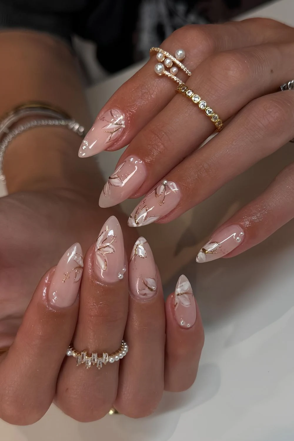 Neutral glossy mani with white florals and gold chrome outlines