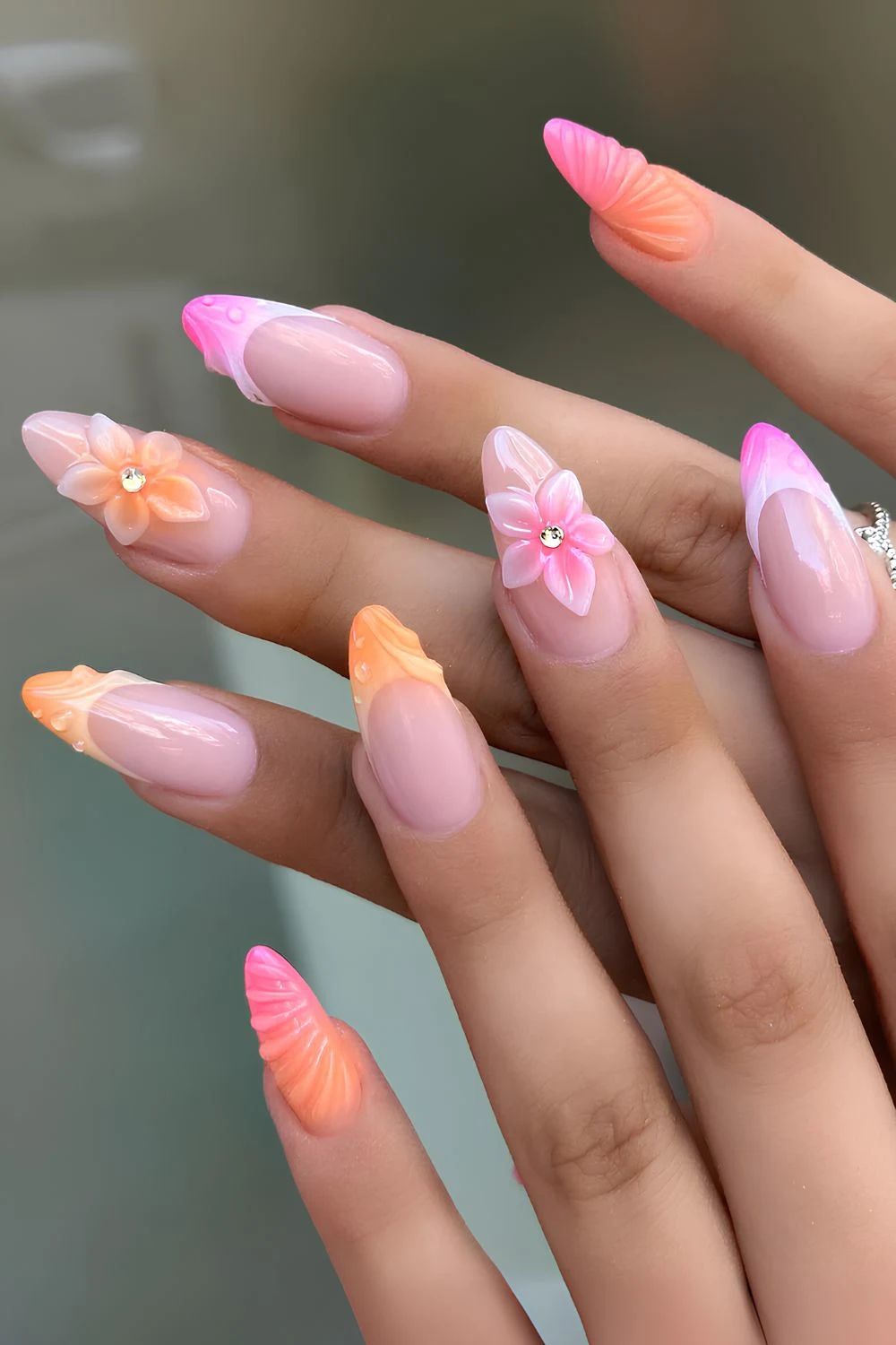 Pink and orange nails with textured florals and swirls