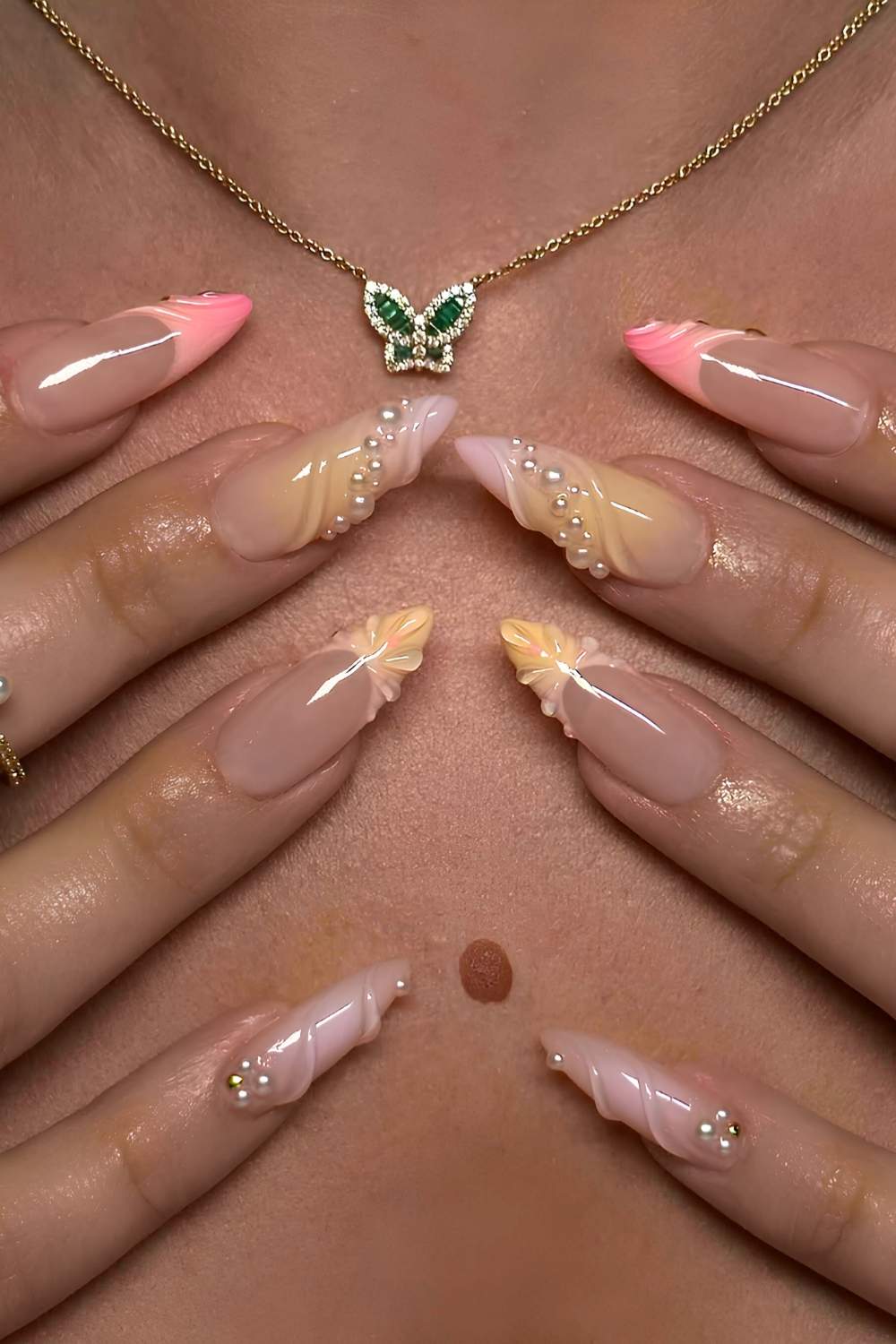 Pink and yellow nails with raised swirls and pearls