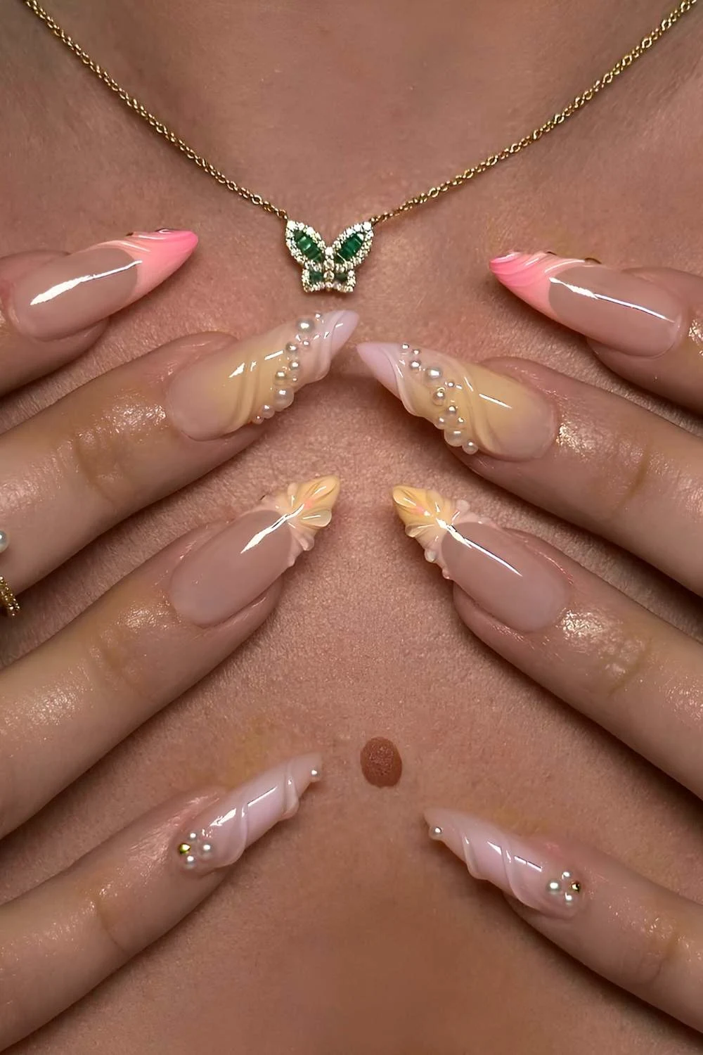 Pink and yellow nails with raised swirls and pearls