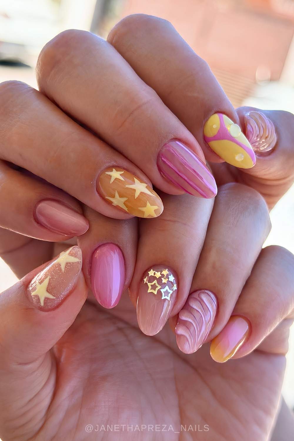 Pink and yellow nails with stars and line art