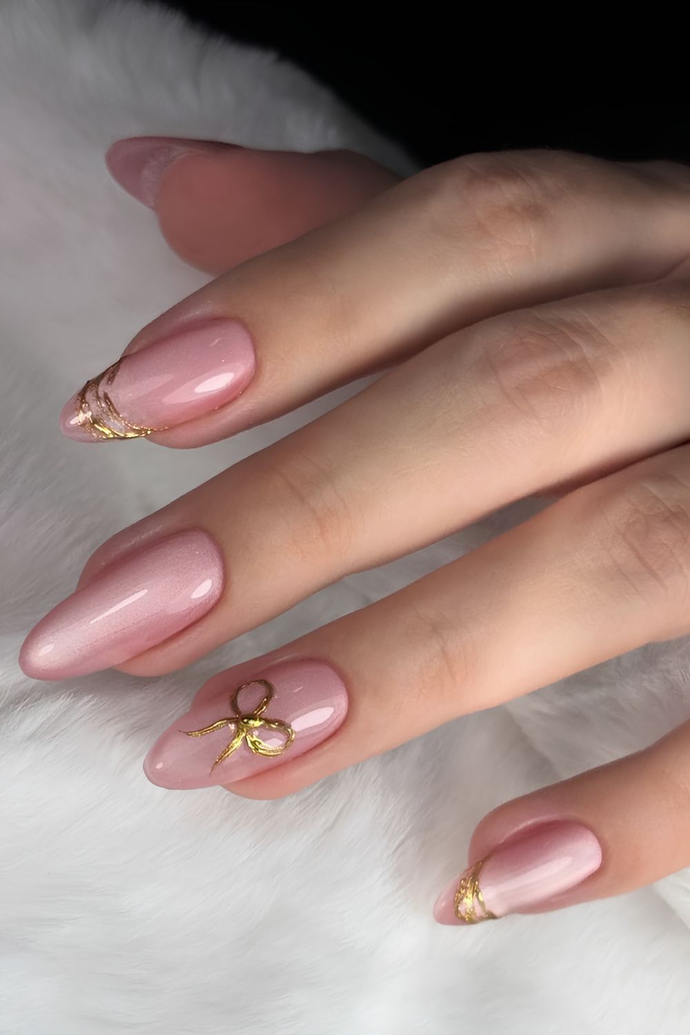 Pink cat eye nails with gold bow accents