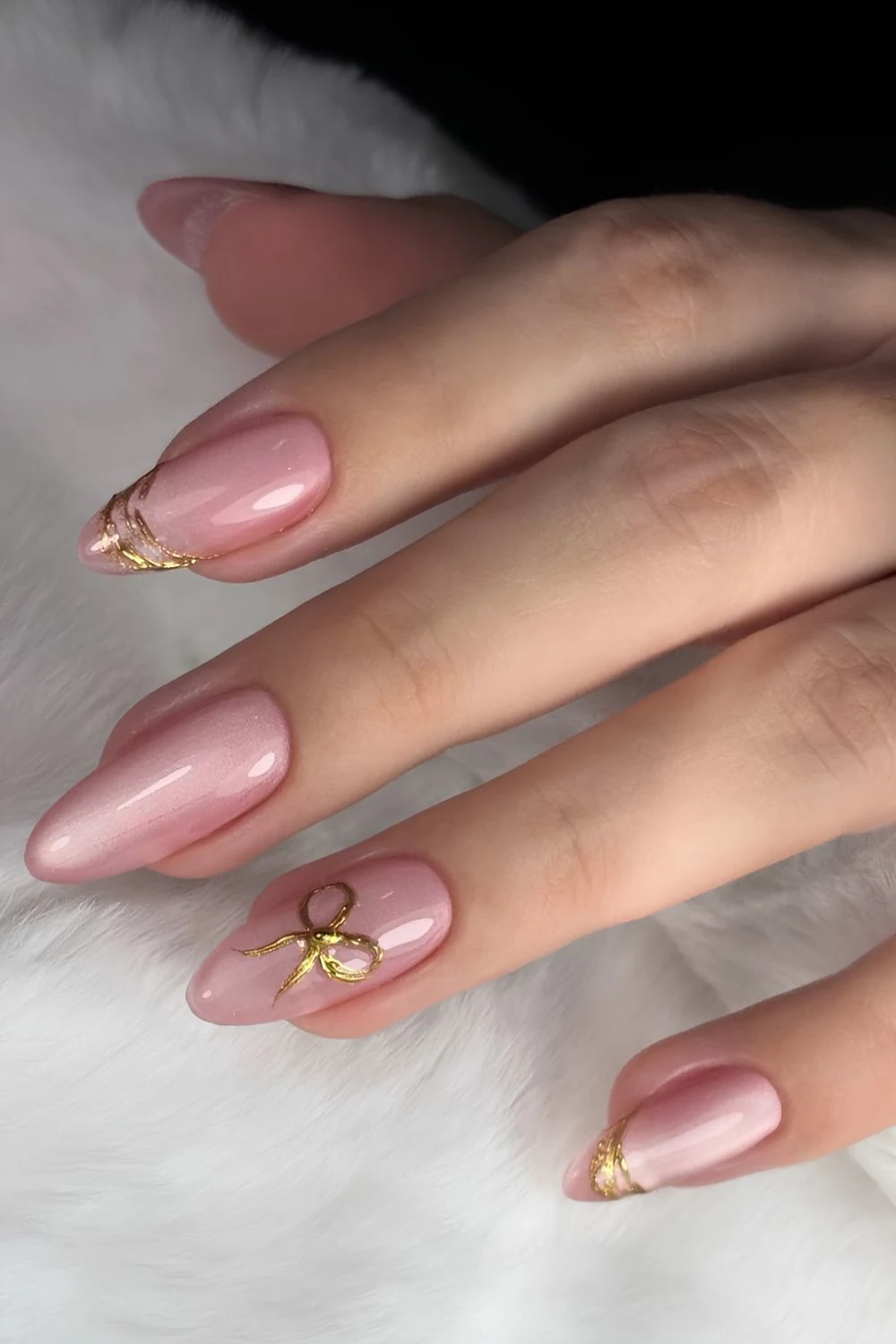 Pink cat eye nails with gold bow accents