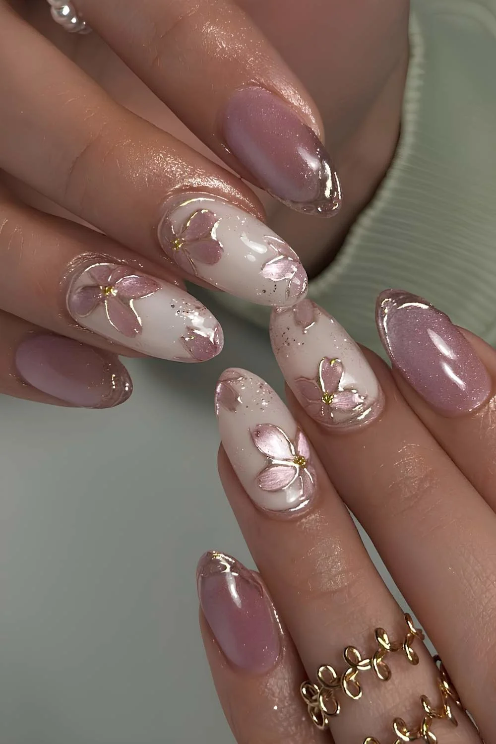 Pink cat eye nails with white and gold accents