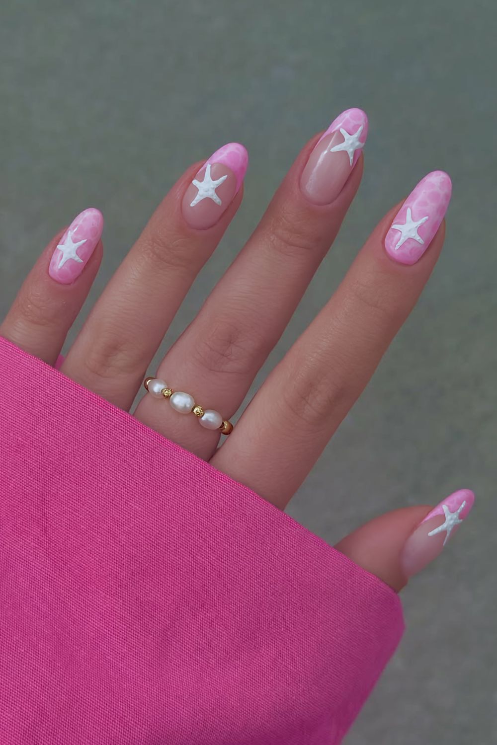 Pink water effect nails with white starfish accents