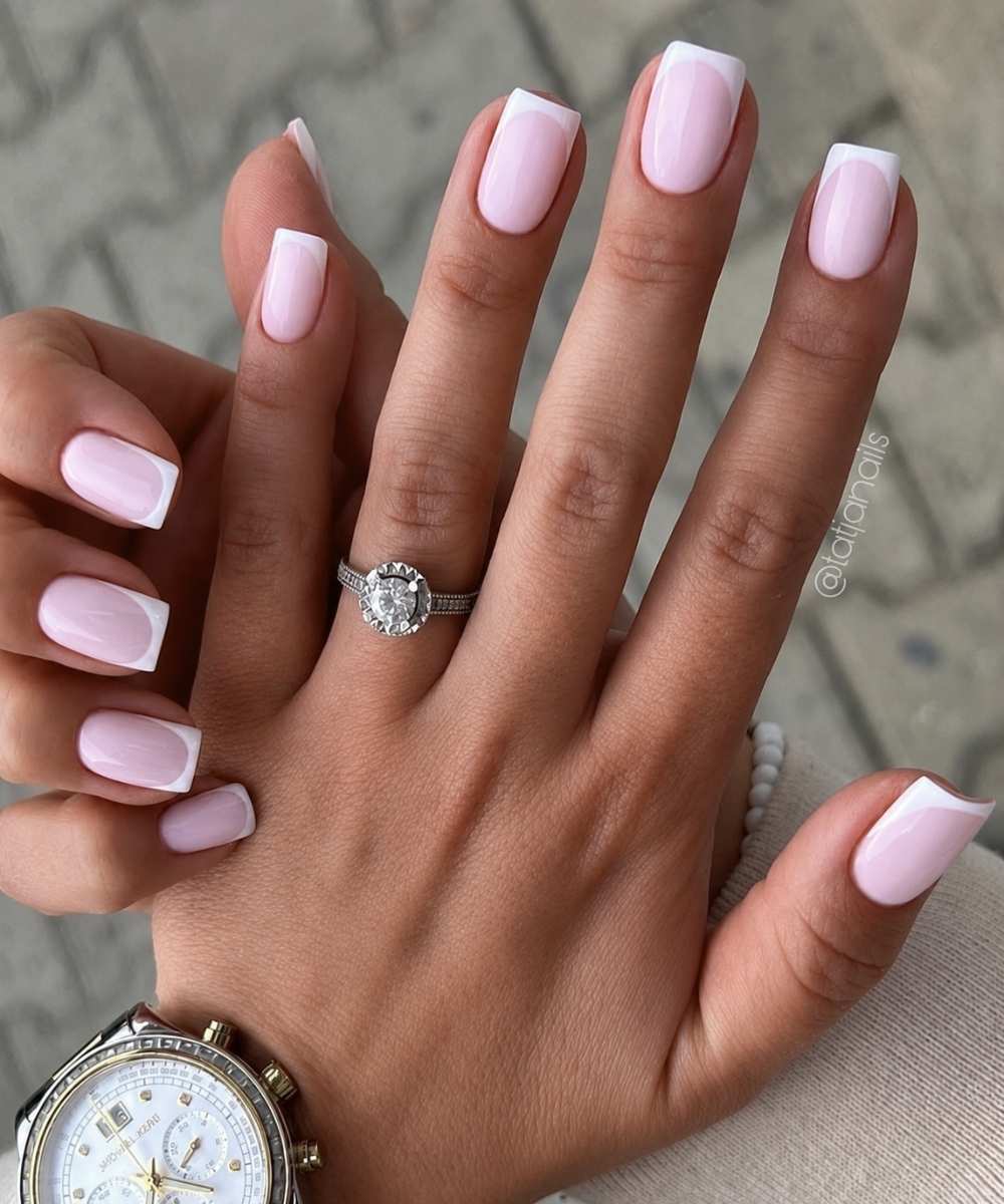 Short white French nails on pink base