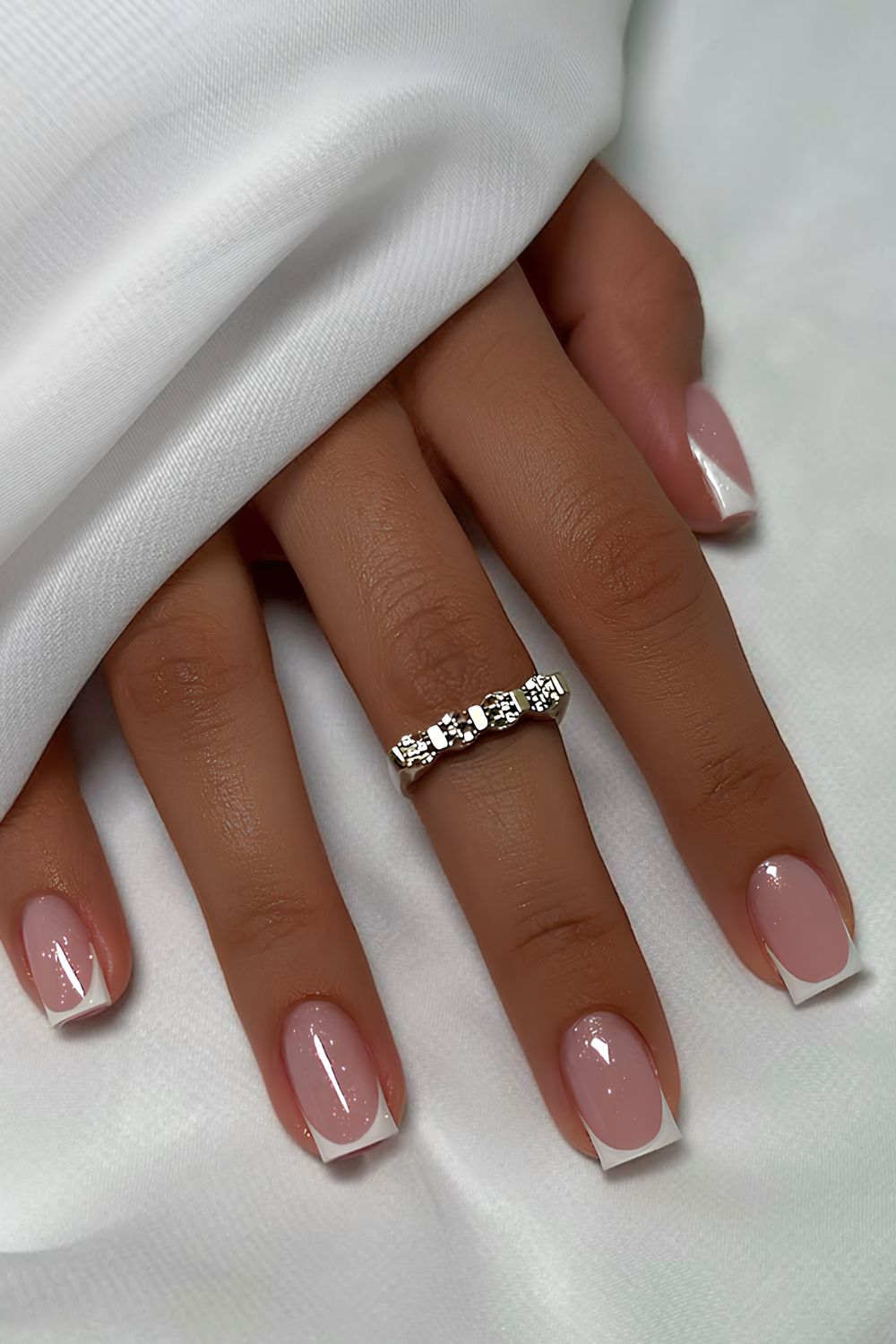 Short white French nails with shimmer