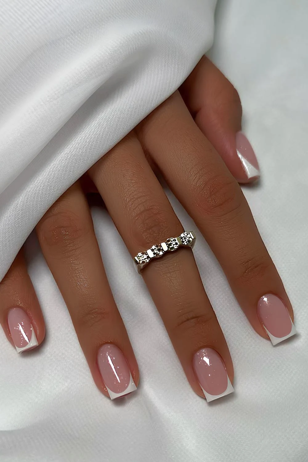 Short white French nails with shimmer