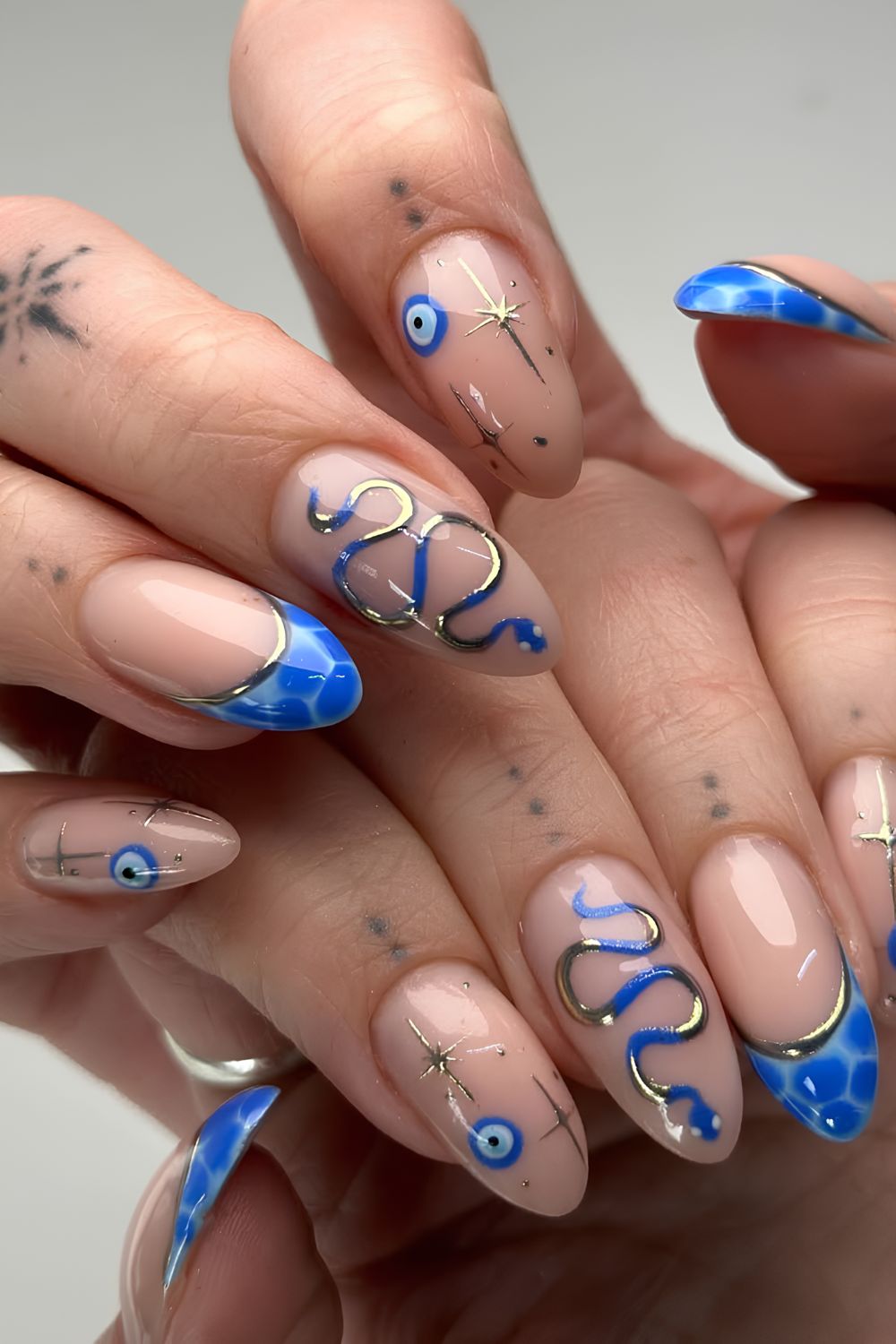 Snake print French tips with gold chrome snake celestial and evil eye design
