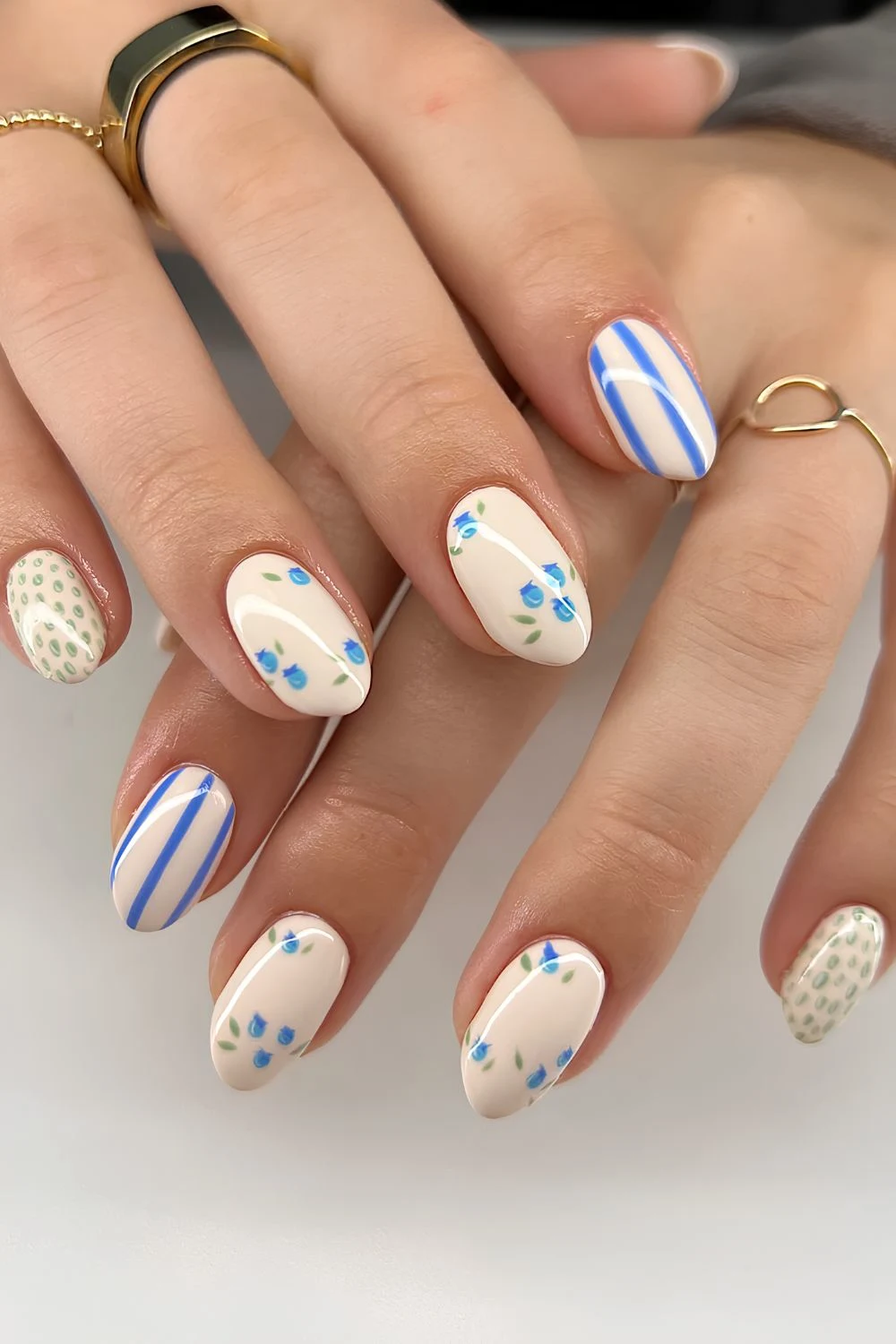 Beige nails with blue stripes blueberies and green dot pattern