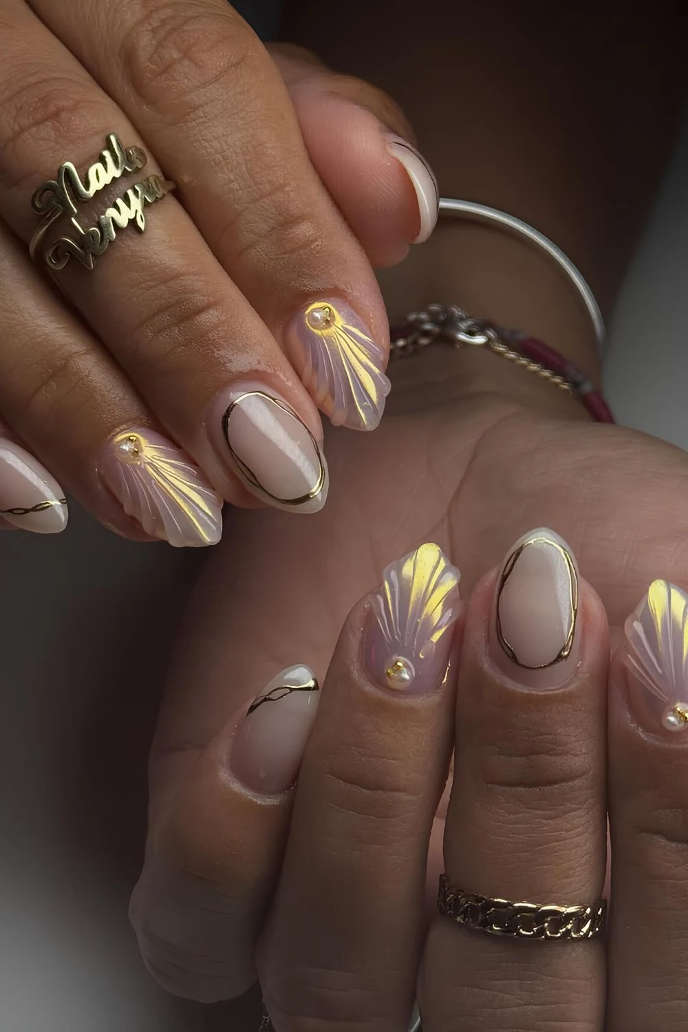 Chrome aurora nails with gold chrome accents and seashell design