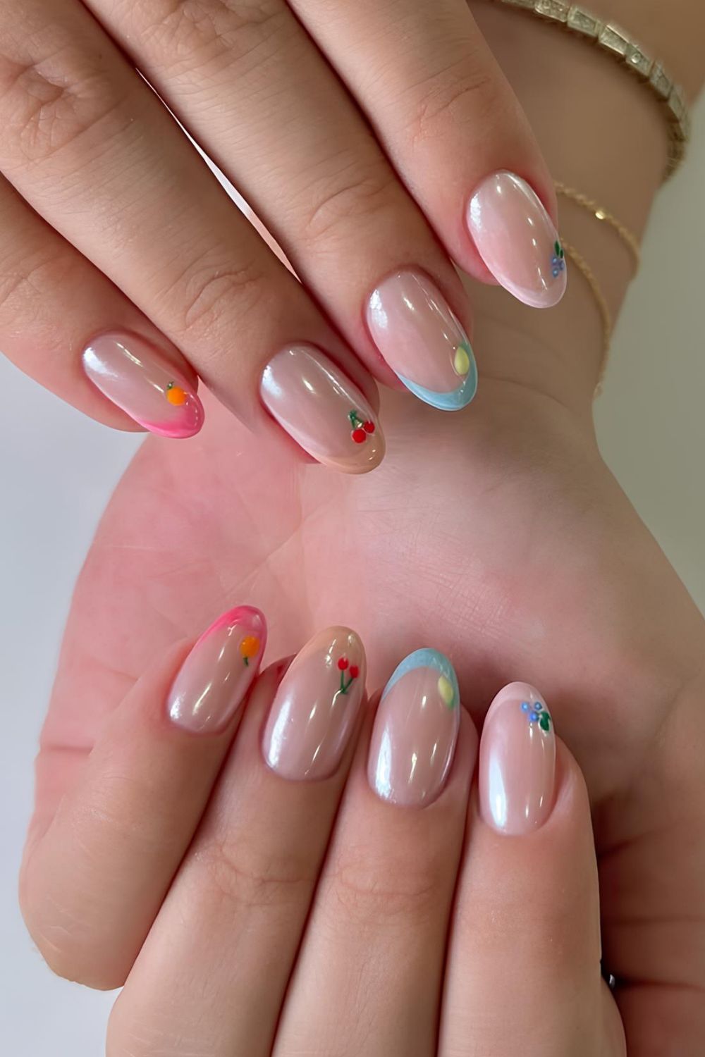 Colorful French tip nails with fruit accents and chrome finish