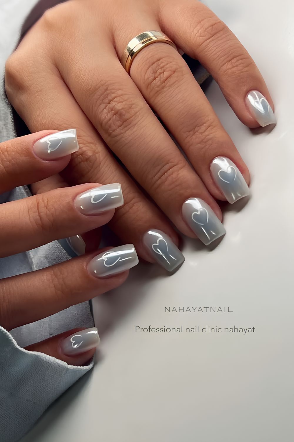 Light blue chrome nails with aura effect and white hearts