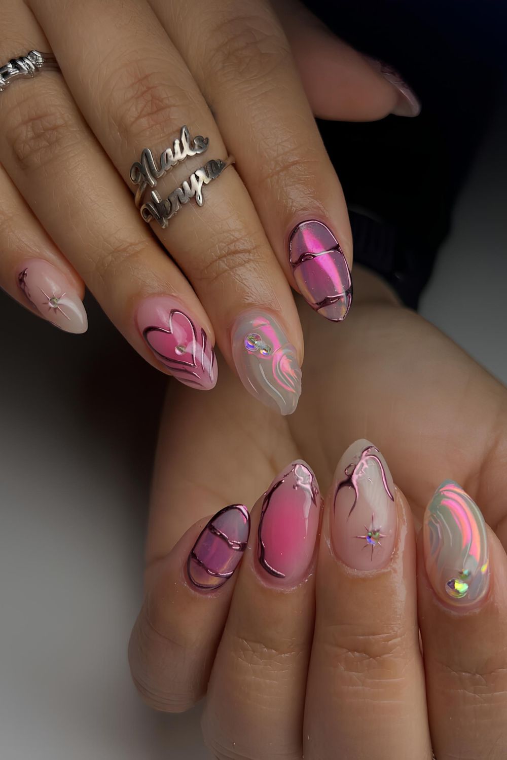 Pink and white aurora nails with chrome accents and raised swirls