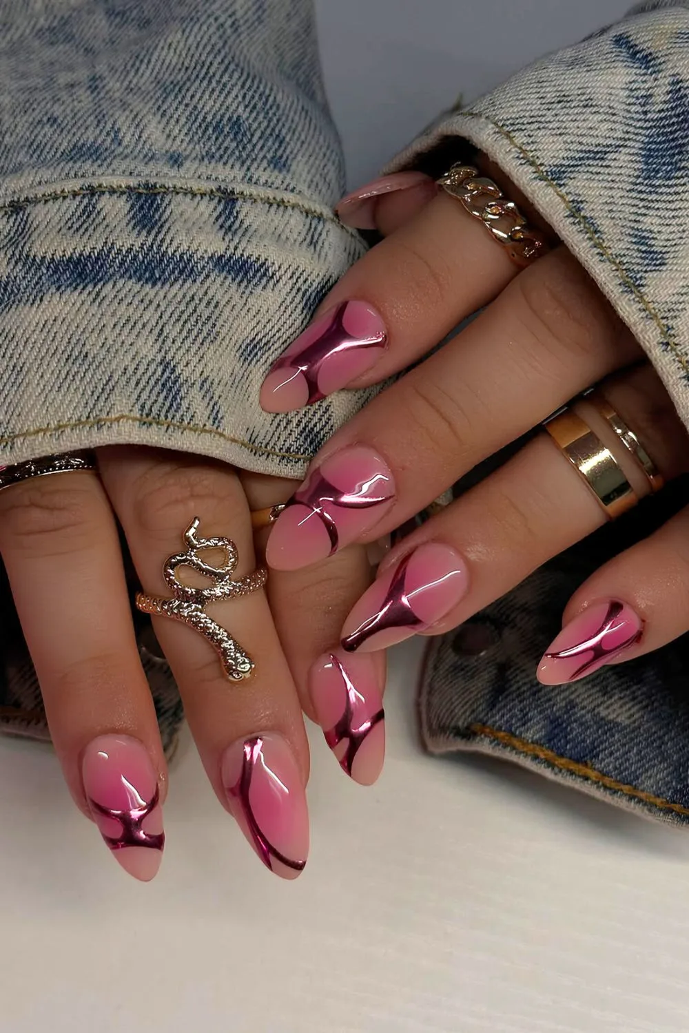 Pink aura almond nails with metallic pink chrome swirls