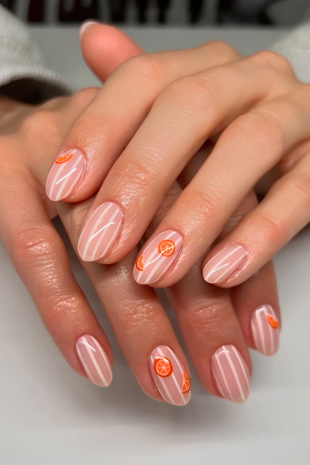 Sheer pink nails with white stripes and orange slice motives