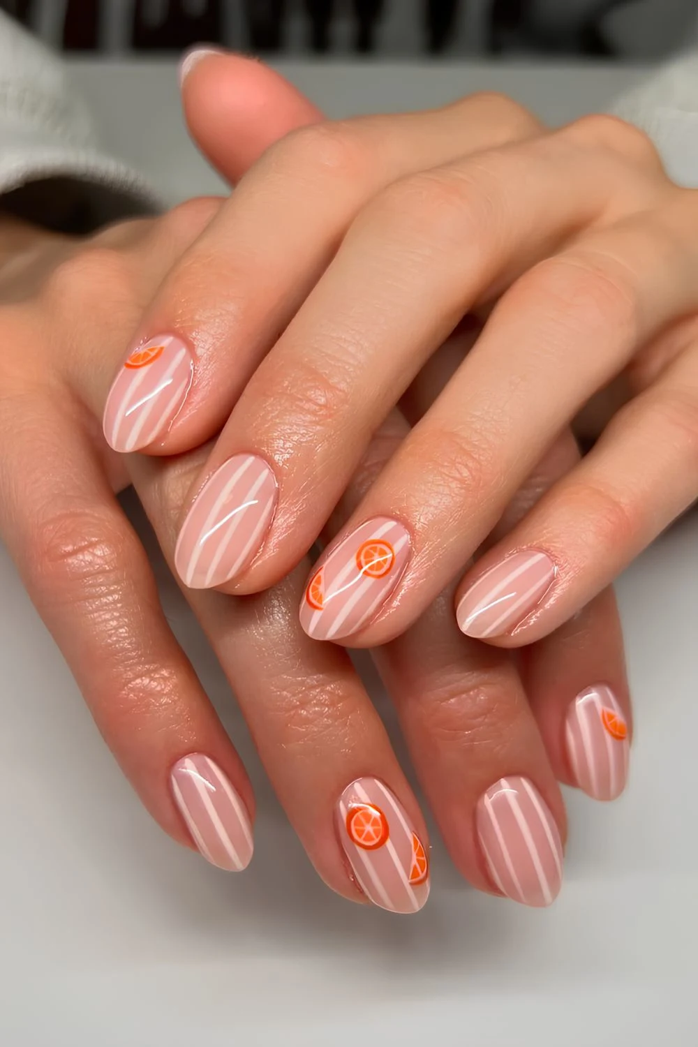 Sheer pink nails with white stripes and orange slice motives