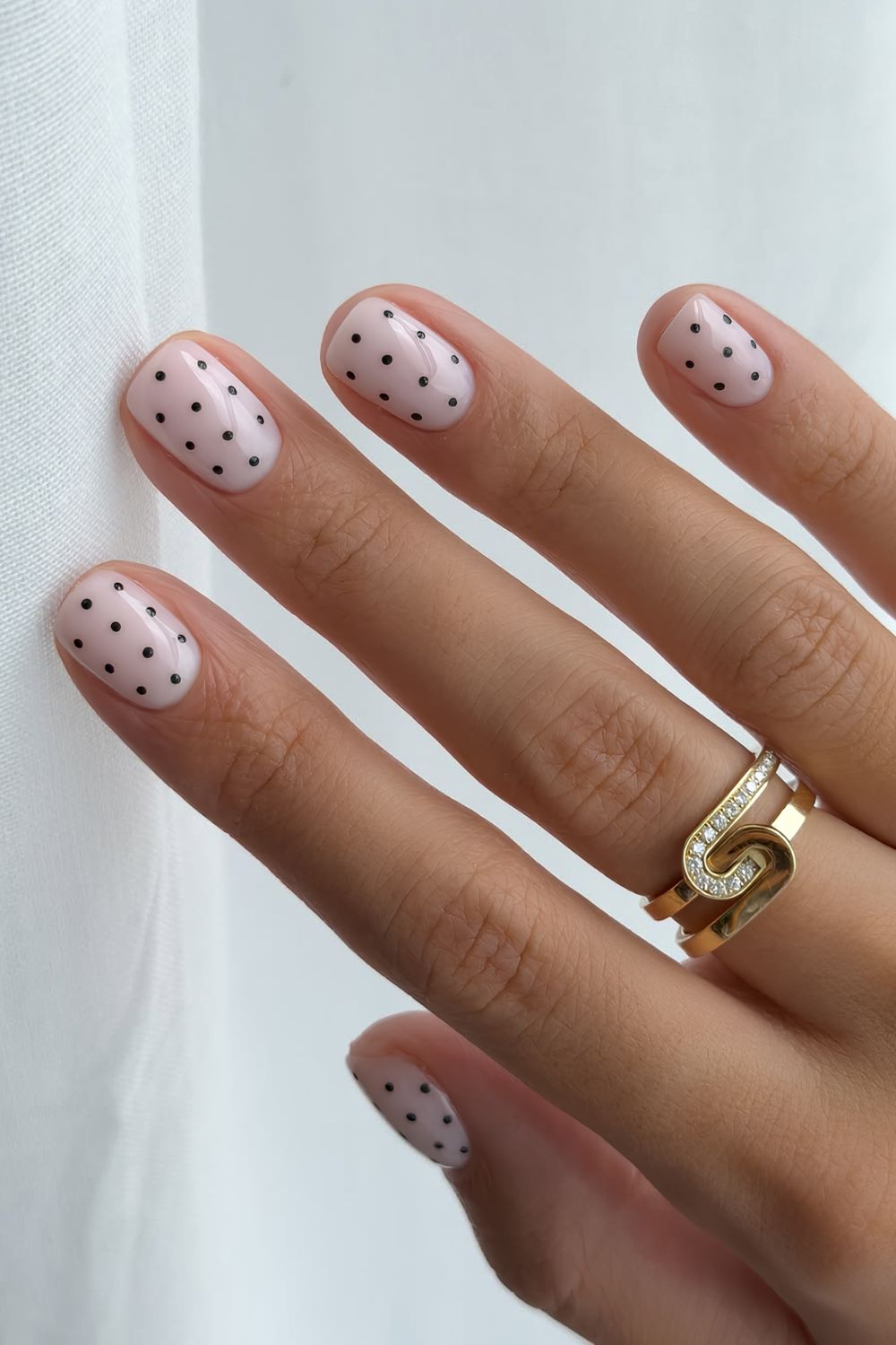 Short milky white nails with black polka dots