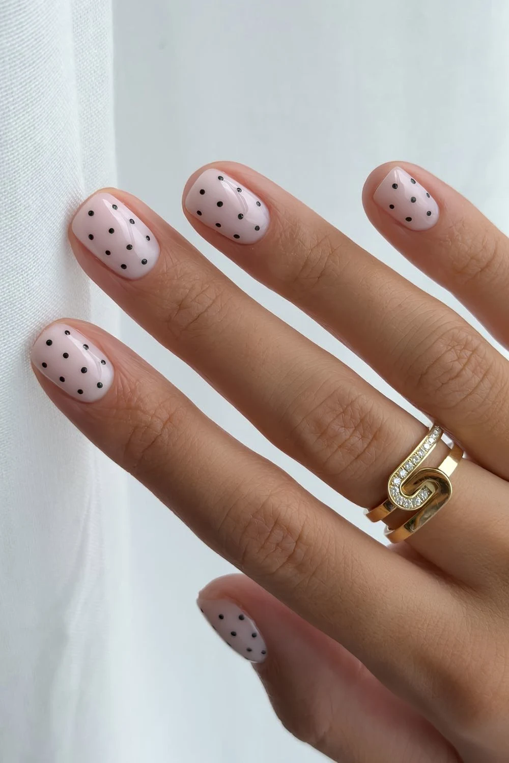 Short milky white nails with black polka dots