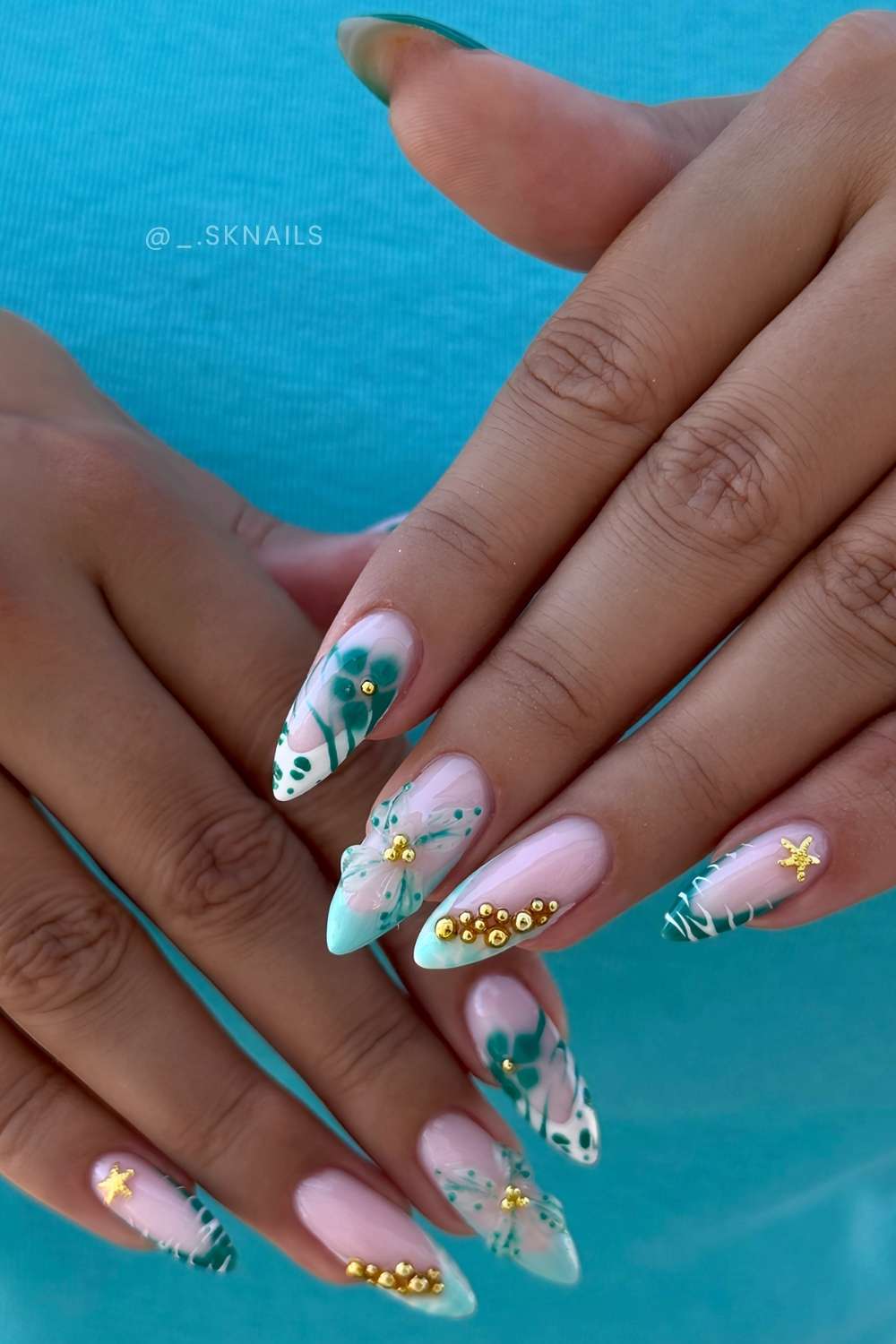Teal summer nails with flowers and gold charms