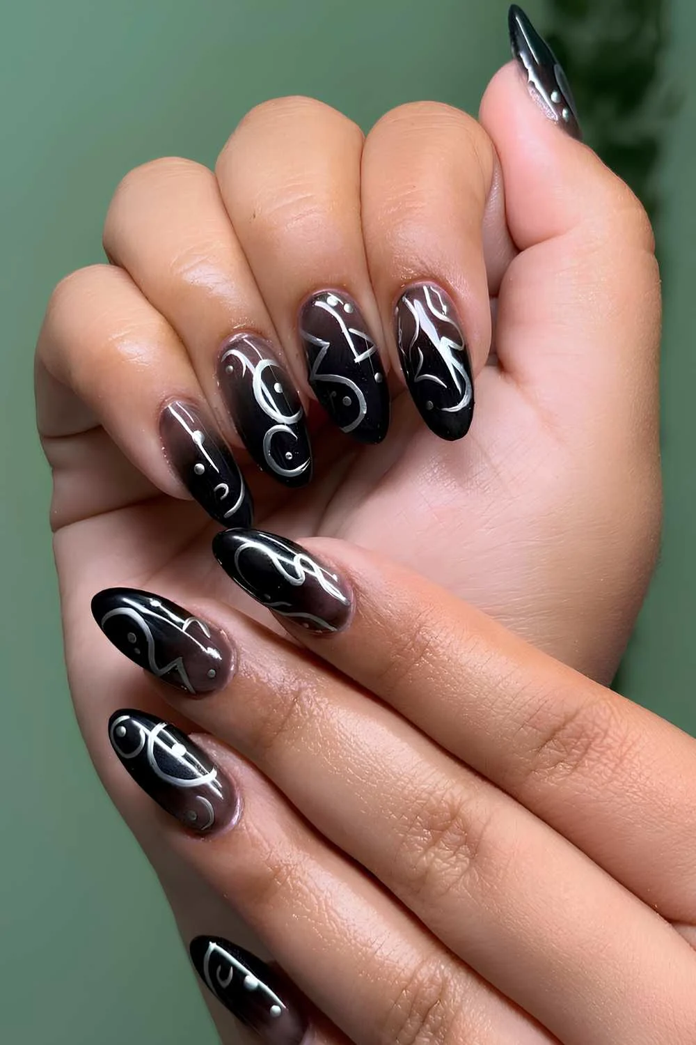 Black ombre nails with silver chrome swirls
