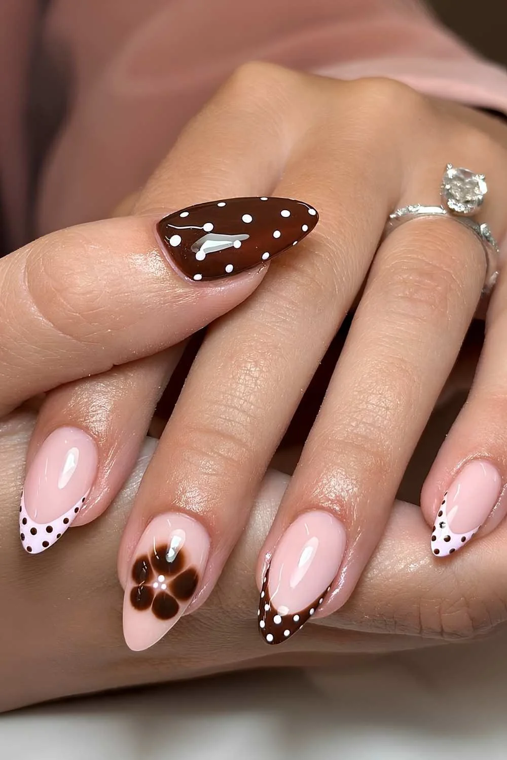 Brown and pink polka dot French tips with blooming flower accent