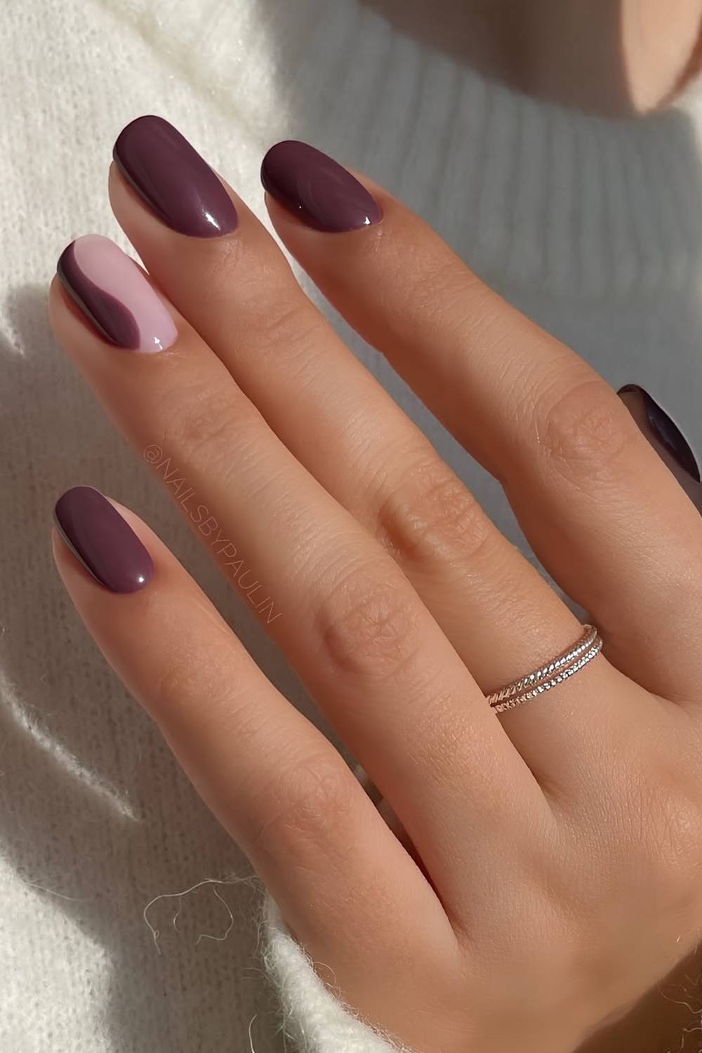 Dark purple nails with abstract swirl accent