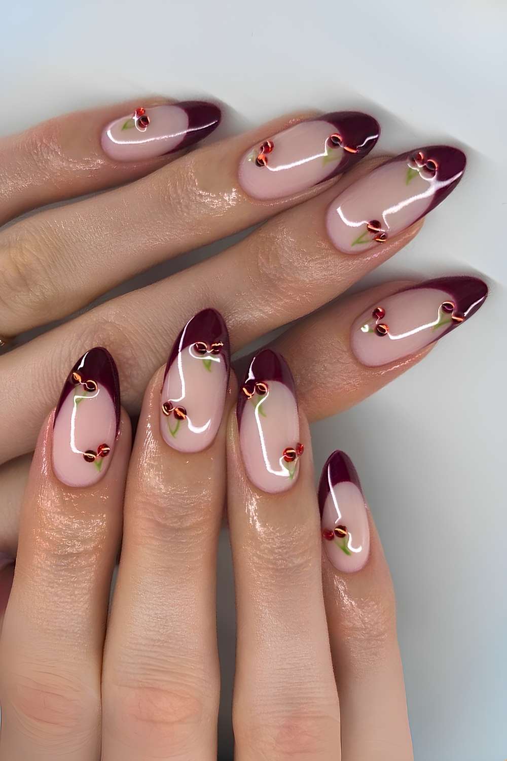 Dark red French mani with cherry rhinestone art