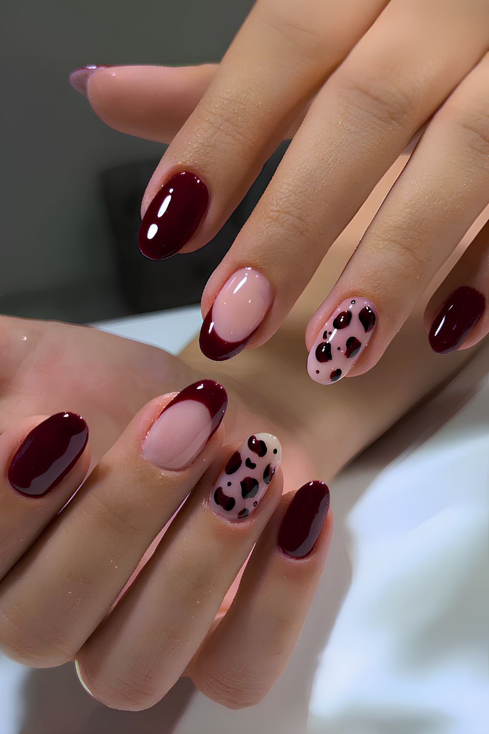 Dark red nails with leopard spot accents