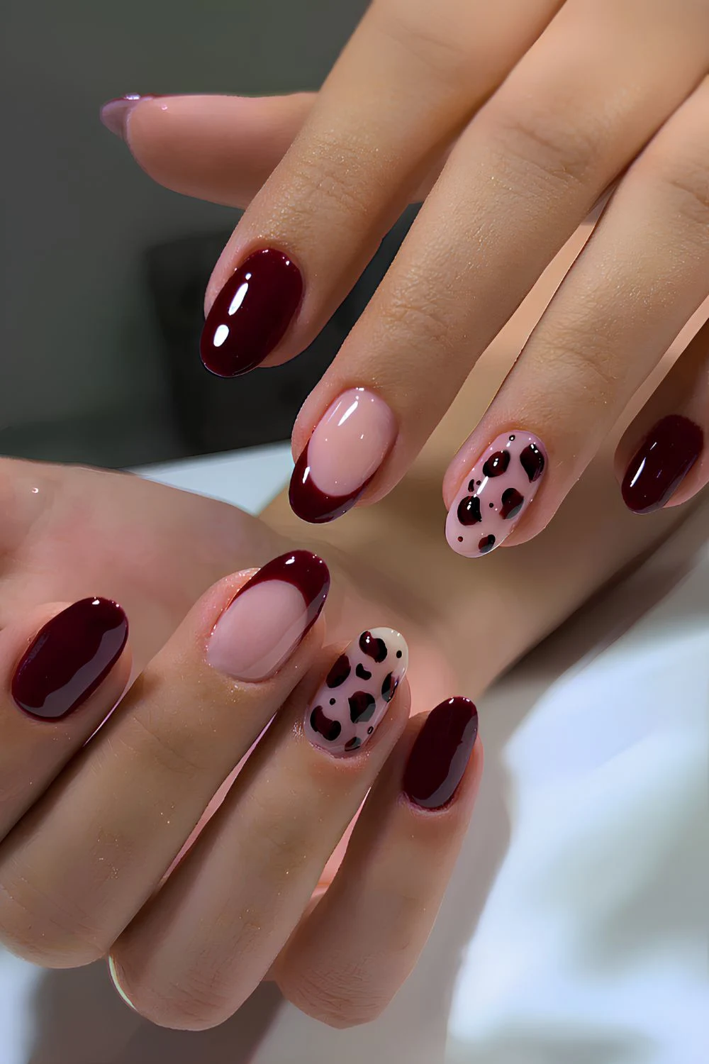 Dark red nails with leopard spot accents