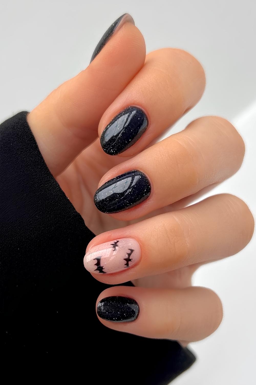 Glittery black nails with bat wing art