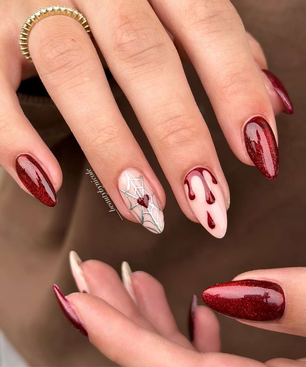 Glittery red mani with spiderwebs and blood drip art