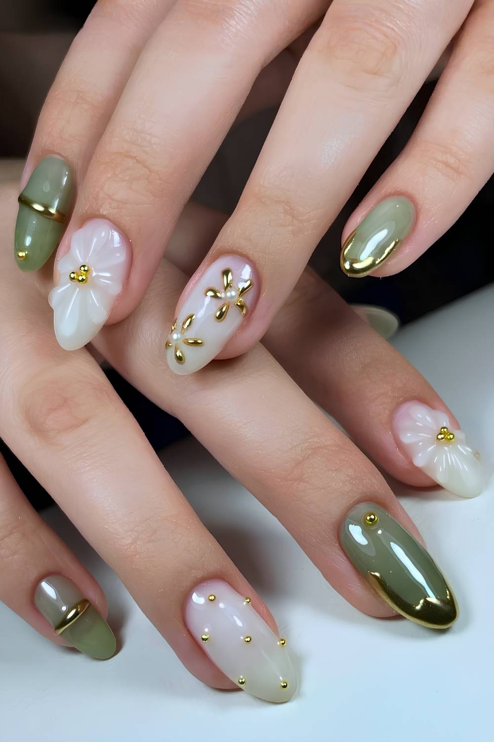 Green and white nails with sculpted gold and floral accents