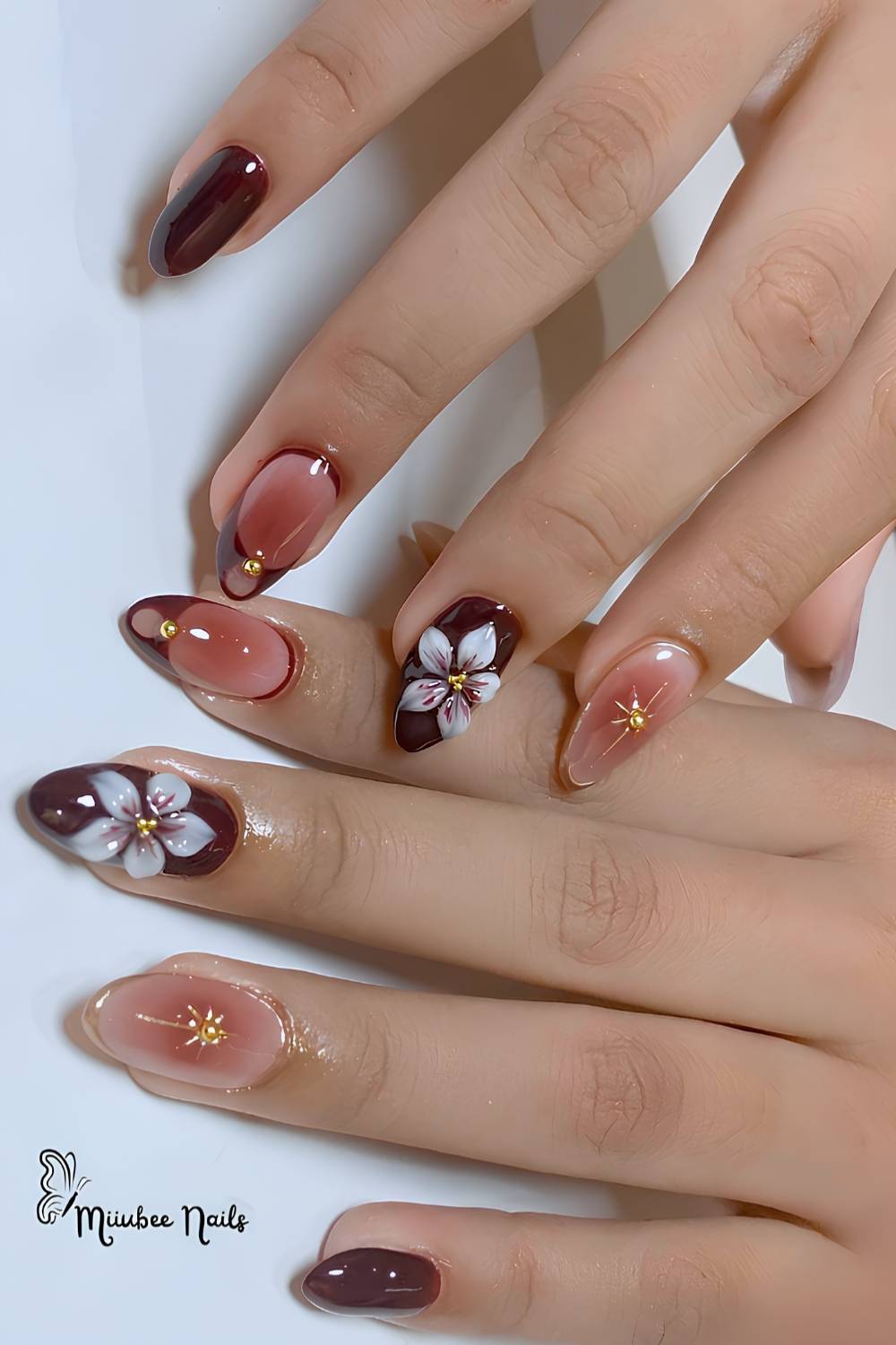 Maroon nails with sculpted flowers