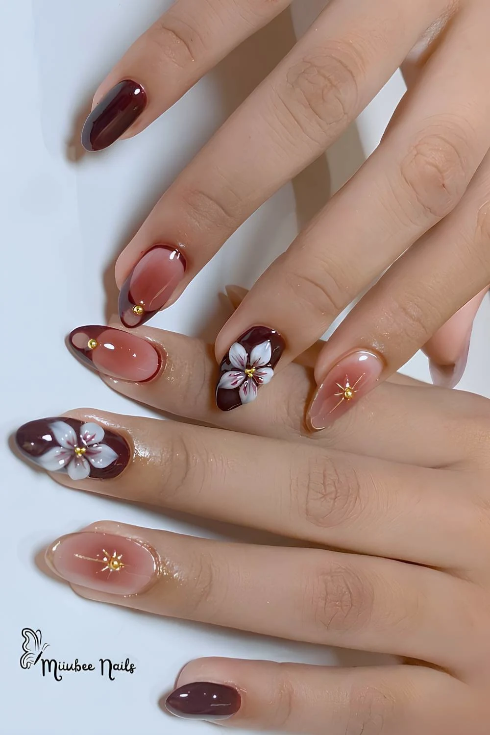 Maroon nails with sculpted flowers