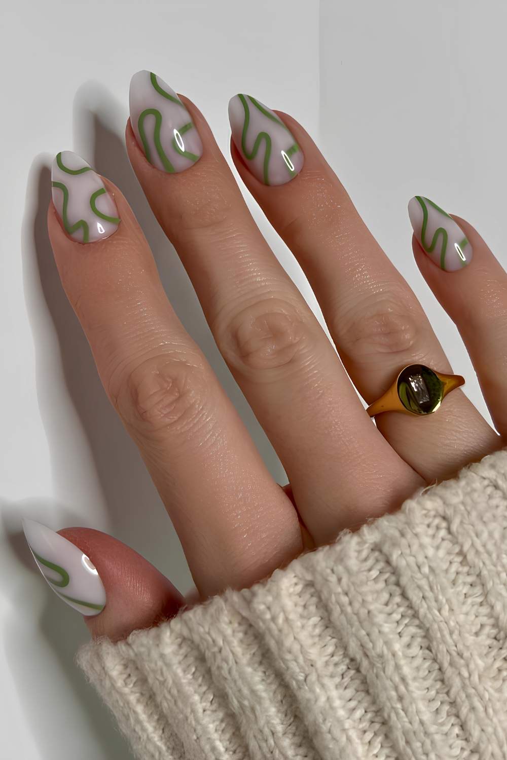 Milky white nails with green swirls