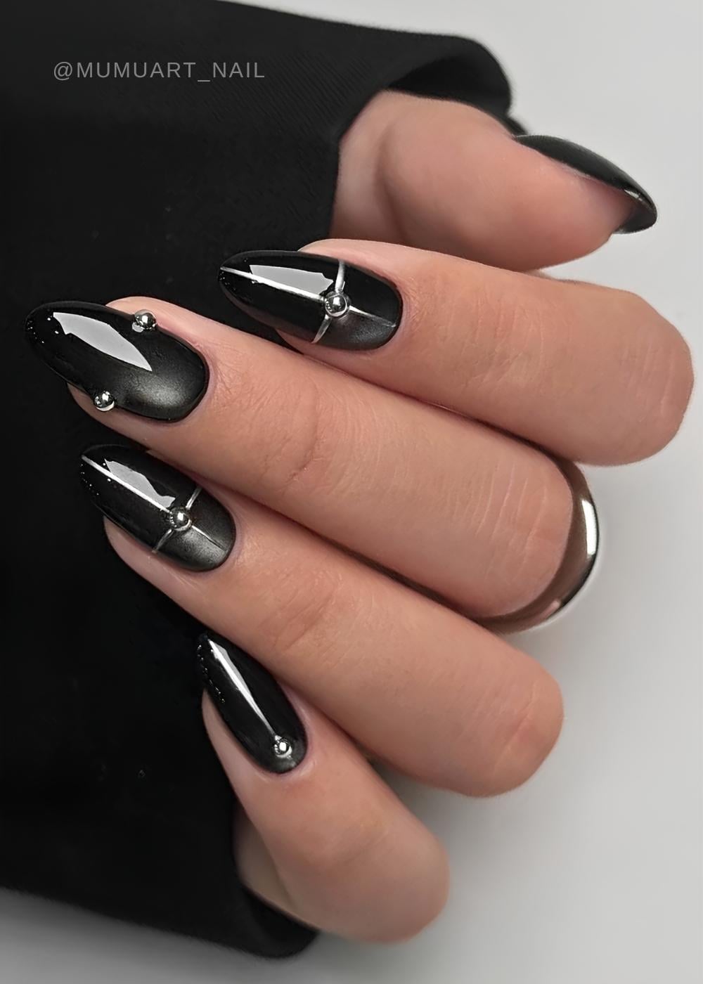 Black cat eye nails with silver lines and studs