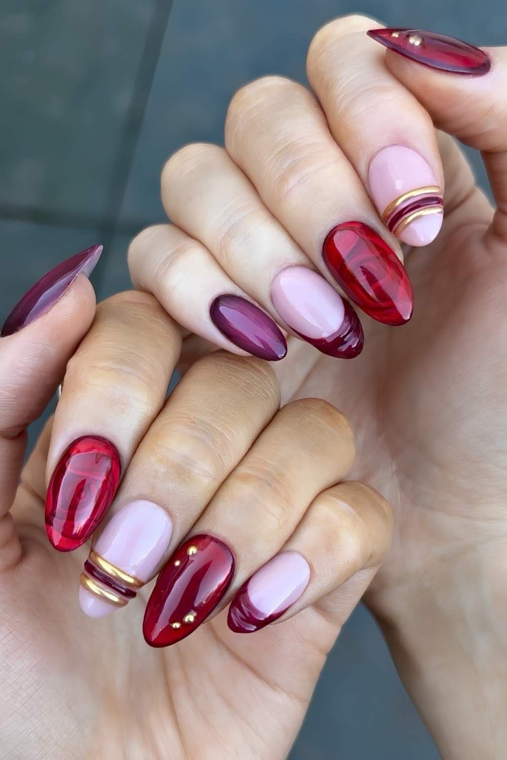 Deep red nails with gold bracelet inspired art