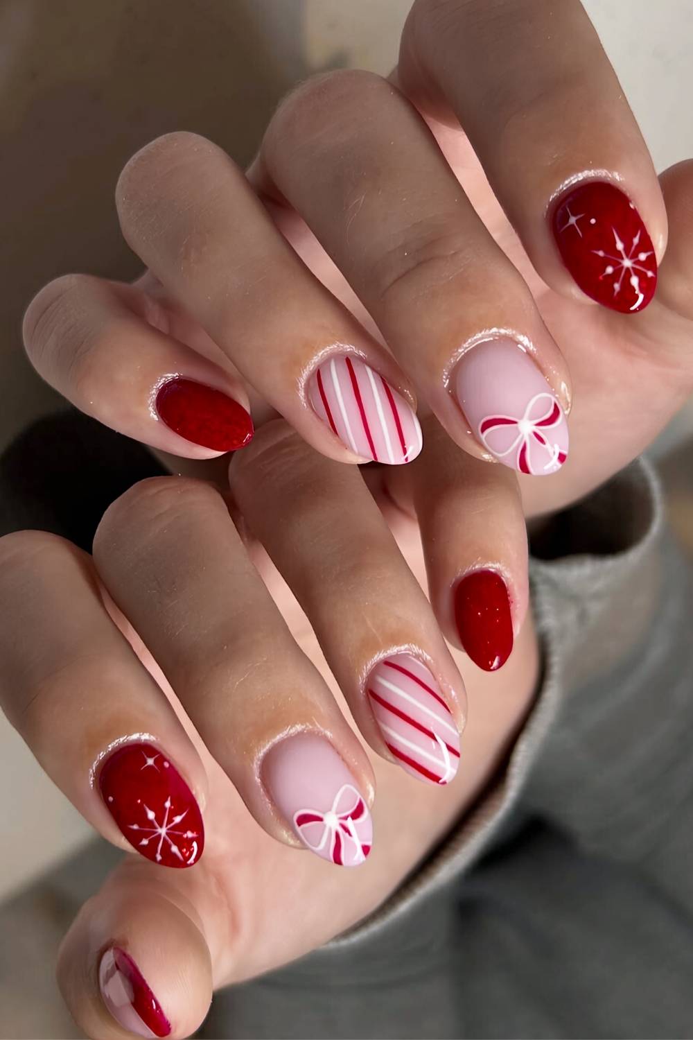 Red and white nails with stripes and bow art