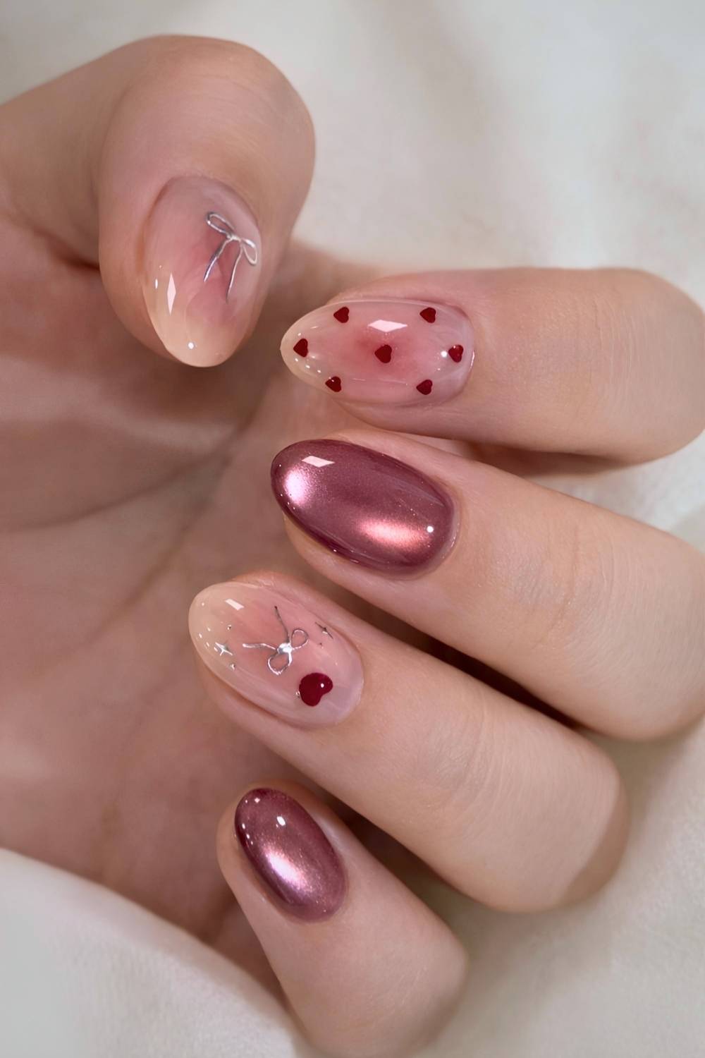 Deep red cat eye mani with bows and hearts