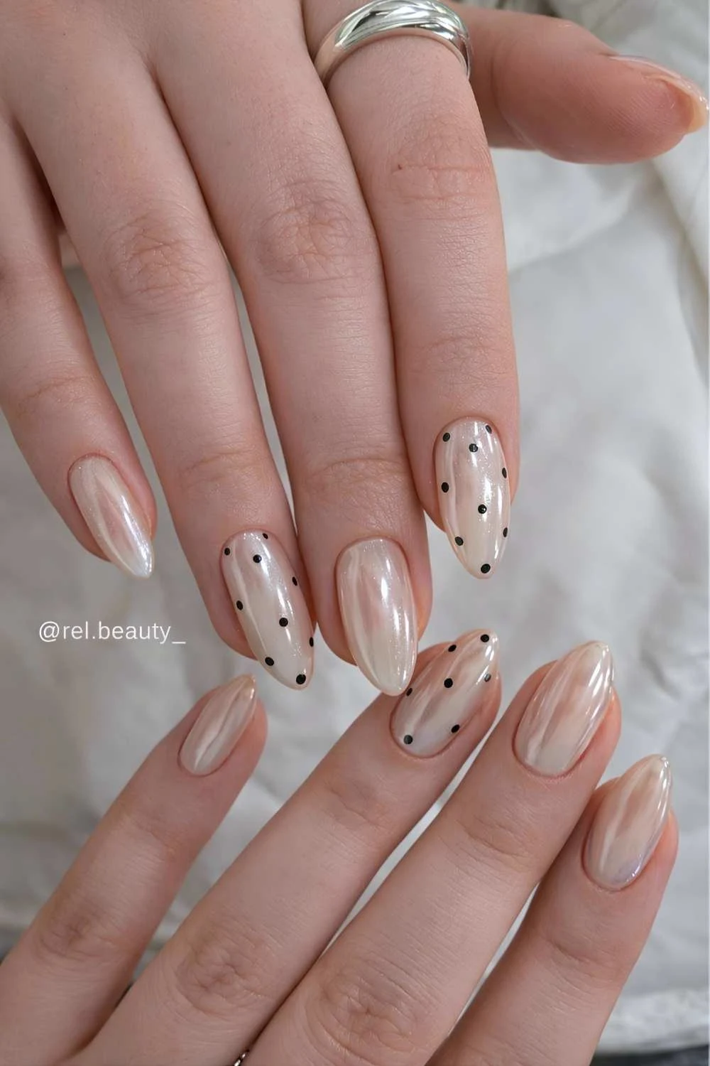 White chrome nails with black polka dots