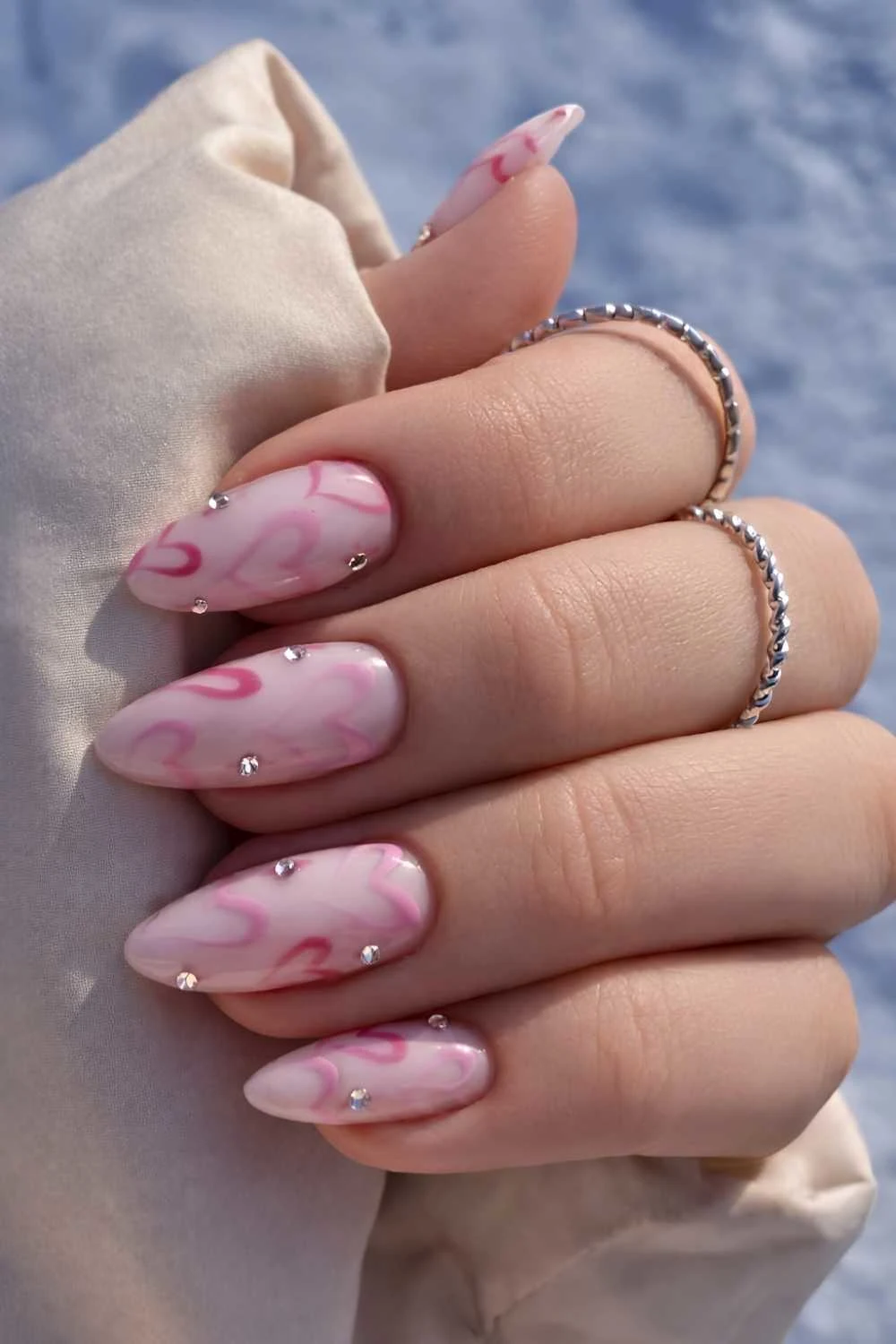 White nails with pink hearts and gems