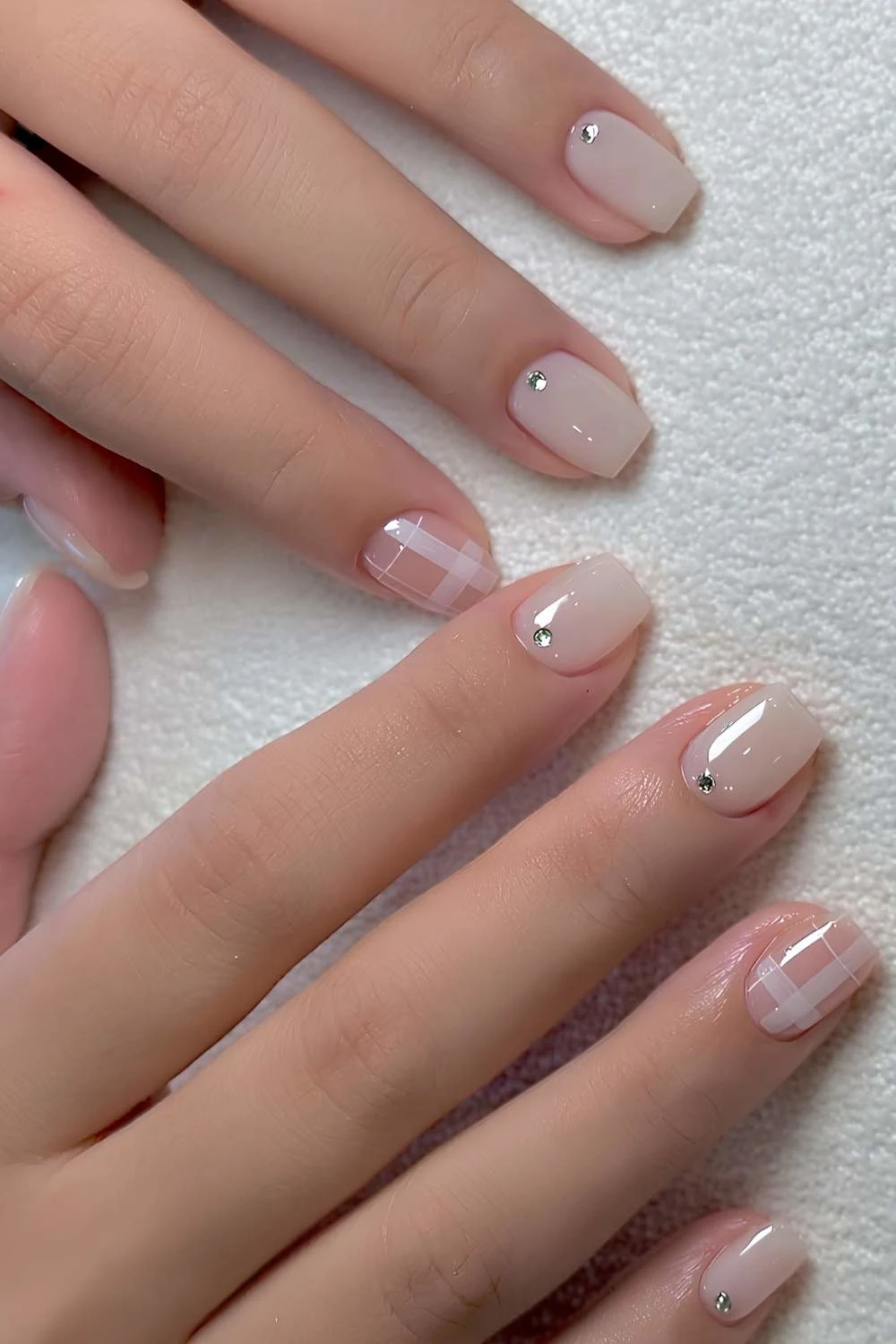 White nails with rhinestones and plaid art