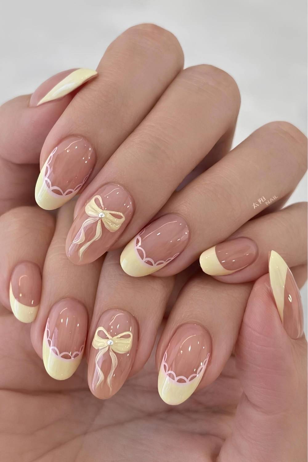 Butter yellow nails with lace and bow art
