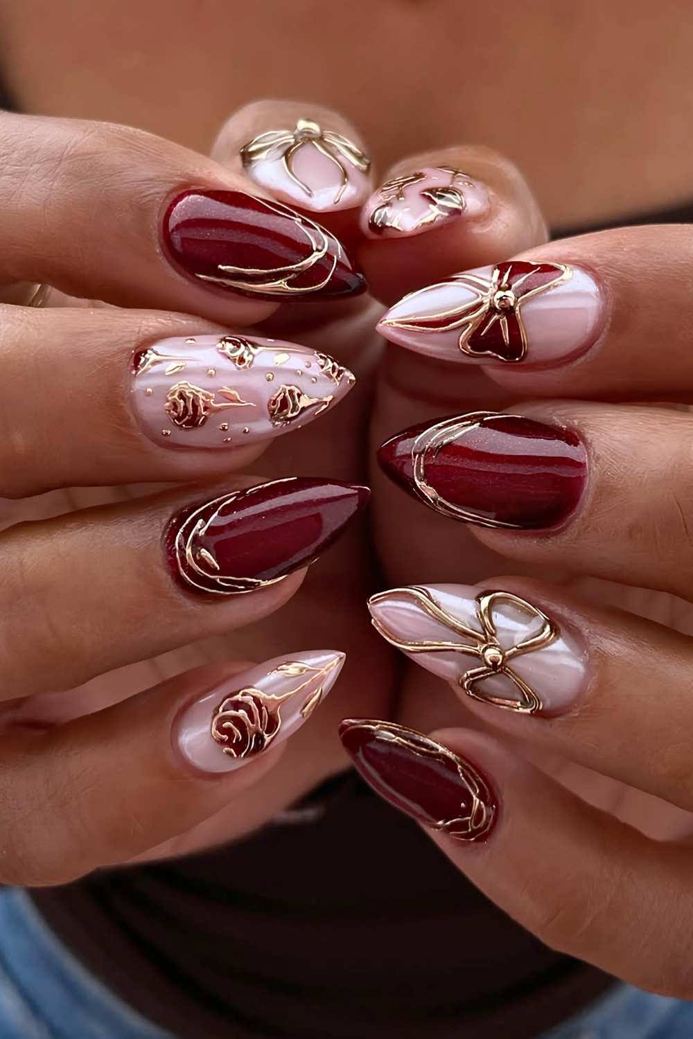 Burgundy nails with gold rose art and bows